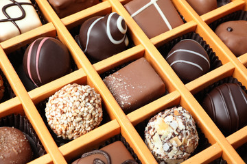 Box with different chocolate candies as background, closeup
