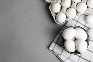 Flat lay composition with raw chicken eggs on grey table. Space for text