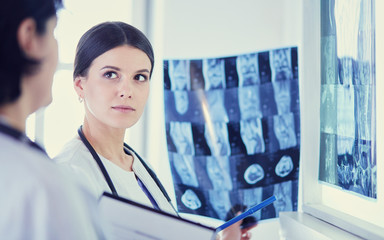 Two female doctors looking at x-rays in a hospital