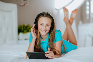 Cute young teen girl listening music at laptop