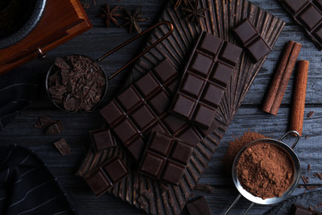Flat lay composition with dark chocolate on black wooden table