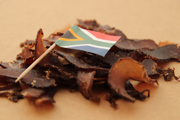 Biltong (dried meat) on a wooden board, this is a traditional food snack that can be found in South Africa.
