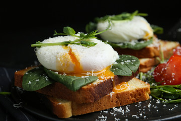 Delicious poached egg sandwich served on slate board, closeup