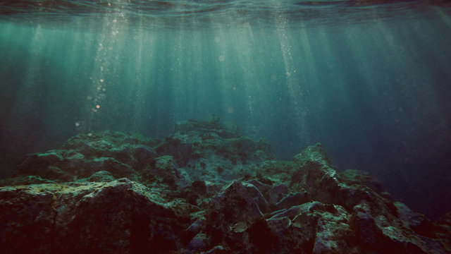 View underwater of waves breaking over rocks