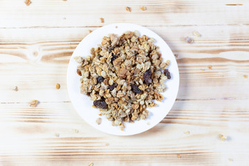 top view on Heap of dry muesli in white plate on wooden background