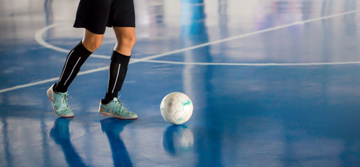 Blurry ball after futsal player control it to shoot to goal. Indoor soccer sports hall.