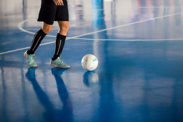 Futsal player control the ball for shoot to goal.