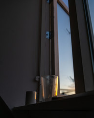 Cup and glass at the window in the sunset