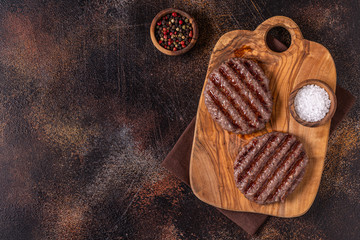 Fried cutlet for burger on a wooden board.