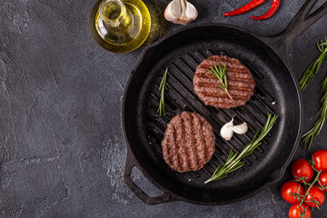 Fried cutlet for burger with spices on grill pan.