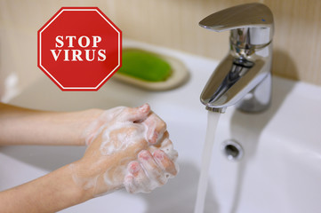 Hand washing as a protection against the virus. Image of a red sign on a photograph.