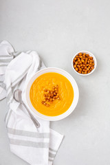 Homemade Butternut Squash Soup in White Bowl on Gray background; Roasted Chickpea Garnish