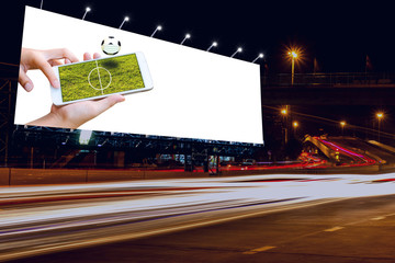 man hand hold and touch screen smart phone or cellphone isolated on billboard with football field on screen 