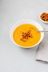 Homemade Butternut Squash Soup in White Bowl on Gray background; Roasted Chickpea Garnish