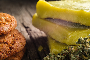 biscuits with marijuana and cannabis butter and bud on an old wooden background close-up. Healthy medical food with cannabis. the buds are inaccurately scattered. rustic. Horizontal.