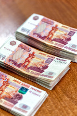 Obraz na płótnie Canvas Piles of paper money five thousand rubles on table closeup