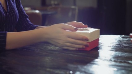 Boyfriend giving gift to his smiling girlfriend at reastaurant