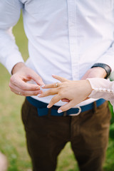 Wedding at an old winery villa in Tuscany, Italy. The groom puts a wedding ring on the brides finger, close-up of hands.