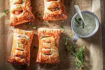 Closeup of fresh sausage roll with sesame and herbs