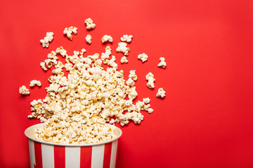 Paper cup with popcorn on a red background