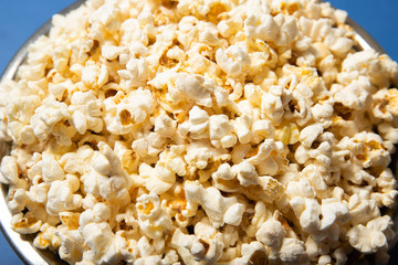Popcorn in a plate close-up. Blue background