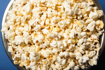 Popcorn in a plate close-up. Blue background