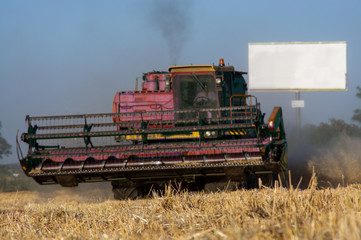 Fototapeta na wymiar Combine machine is harvesting oats on working