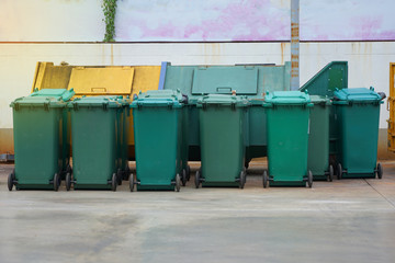 Fototapeta na wymiar Dirty green bins put on concrete waste area for management waste think earth concept at Thailand