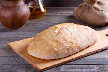 Freshly baked ciabatta bread on wooden cutting board. Ciabatta with ears on the table