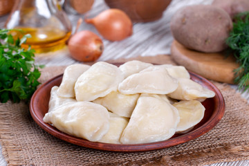 Fototapeta na wymiar Dumplings, filled with mashed potato in plate on wooden table