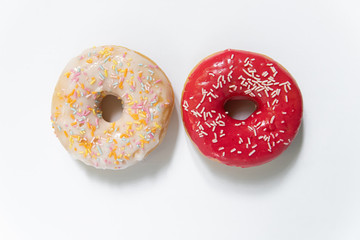 Donut day. Two bright colored donuts with colorful sprinkles on white background. Copy space,...