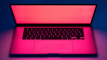 Elegant laptop computer view on a table with red screen light glow and dark blue background.