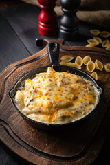 Pasta with cheese and chicken on a black background