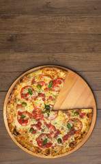 Photograph of Pizza Marguerita made with Mozzarella Cheese, tomatoes, basil leaves and green olives, served on a wooden board. Gastronomic photo of Topo in vertical position with space to write texts
