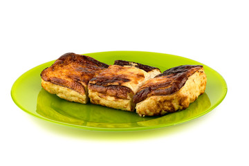 Cottage cheese casserole on a green plate over a white background.