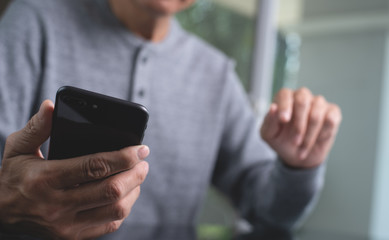 Casual man using mobile smart phone at home