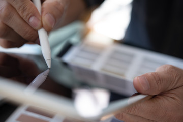 Close up of graphic designer using stylus touching on digital tablet computer working design...