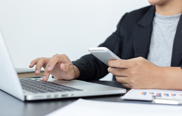 Financial businessmen use laptop and smart phone to analyze marketing strategies and real estate data to reduce company taxes for their customers, Accounting and Tax concept.