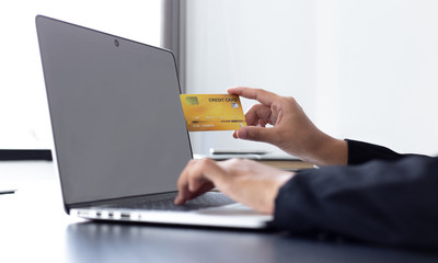 Fototapeta premium women use laptop to register online purchases using credit card payments, Convenience in the world of technology and the internet, Shopping online and banking online concept.