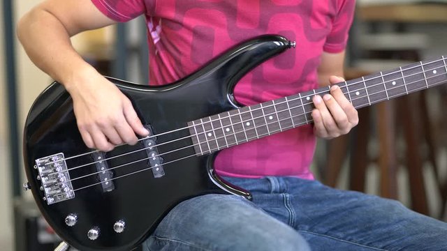 Young musician performing art with bass guitar