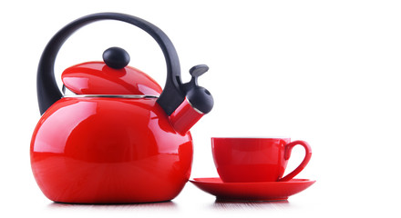 Cup of coffee and stainless steel stovetop kettle with whistle
