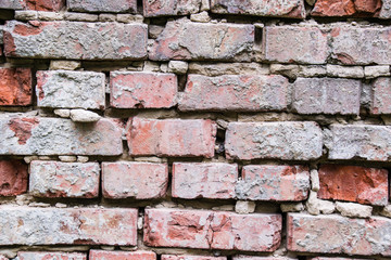 Old red brick wall. The texture of the old destroyed, twisted brickwork