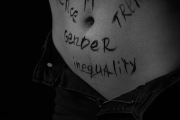 part of the body of a young girl with the inscription gender inequality . the captions are written...