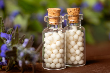 Homeopathic medicine concept. Homeopathy pills in vintage bottles, medical herbs, close up