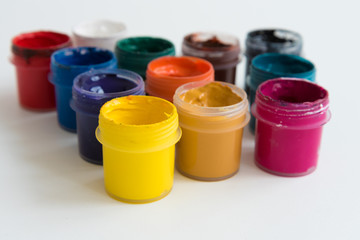 Open cans of paint, top view. Variety, many colors of gouache. Background, texture.