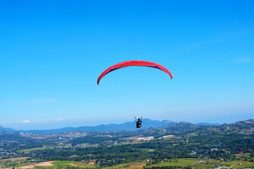 Professional man paragliding in blue sky in a sunny day