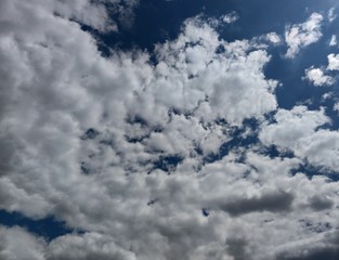Wavy gray and white clouds. A few spots of dark blue sky inside.