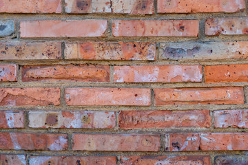 Old red brick wall with cracks, rzhachina and stains. Destruction of the masonry facade of an antique building. Close-up