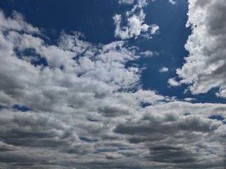Fototapeta na wymiar Stormy gray and white clouds. A few spots of dark blue sky inside.