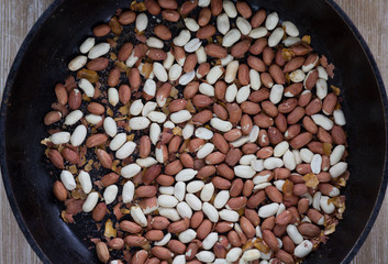 Top view of peanut with seed coat frying on the pan
